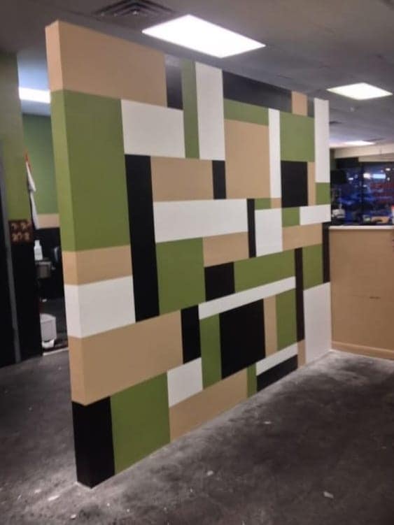 Raised geometric wall panels painted in green, sand and black in an unfinished Visakhapatnam interior
