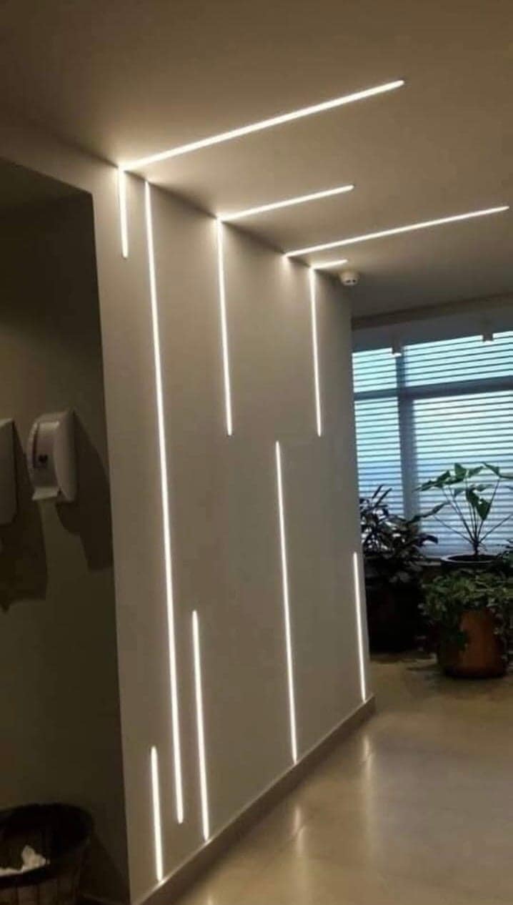 Hallway in a Visakhapatnam home with recessed linear profile lighting running along the ceiling and wall