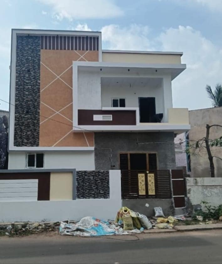 Completed two-storey house exterior in Visakhapatnam with finished elevation and compound wall